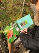 Hiker uses the braille interpretive signs on the Fern Trail
