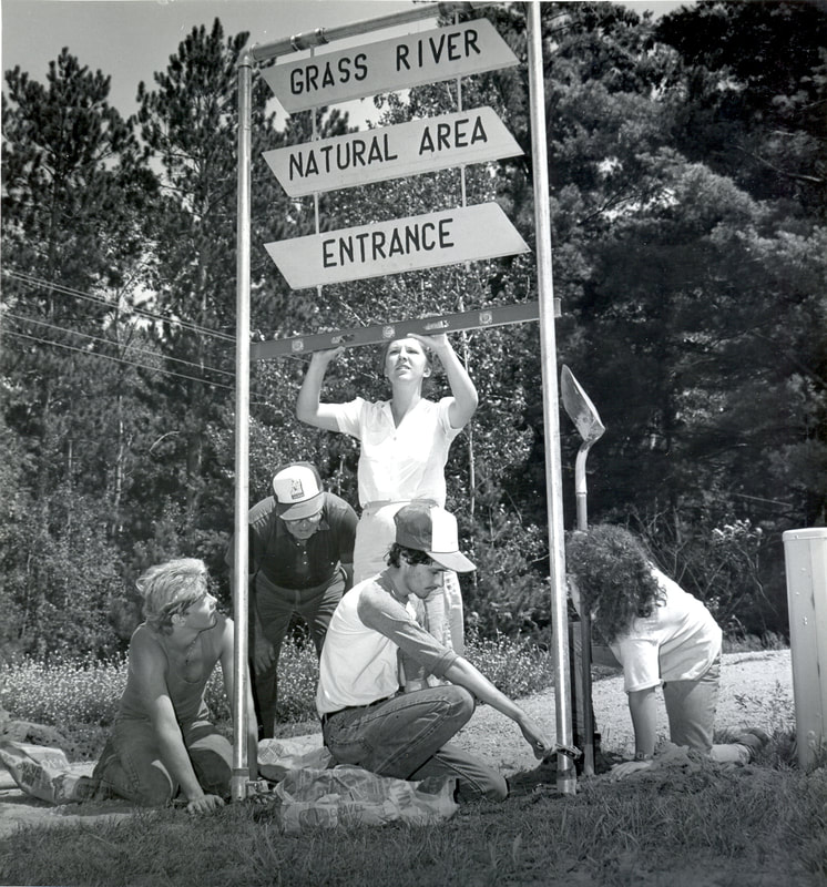 Volunteers install an entrance sign